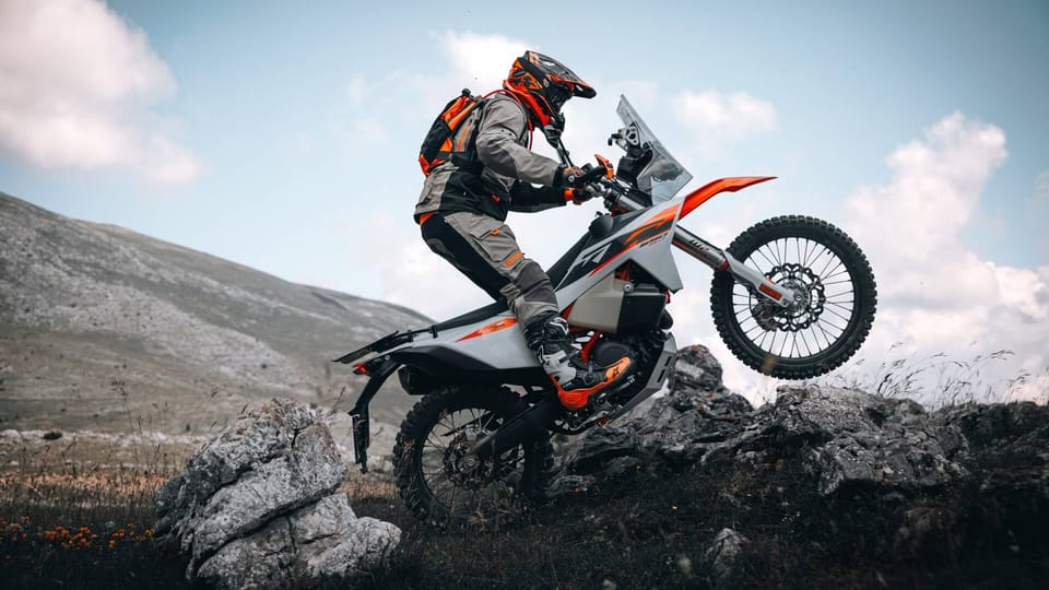 2027 KTM 690 Rally, front three-quarter view, in rally-raid bodywork with windscreen