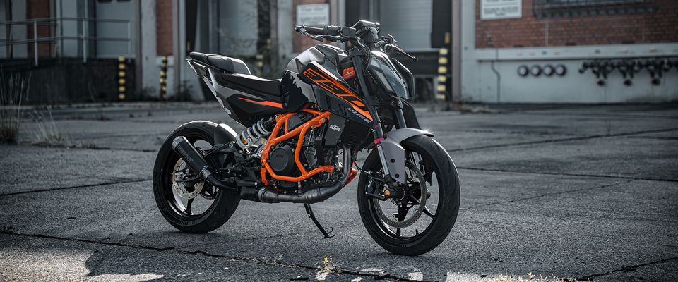 2026 KTM 390 Duke naked bike, orange and black, front three-quarter action shot